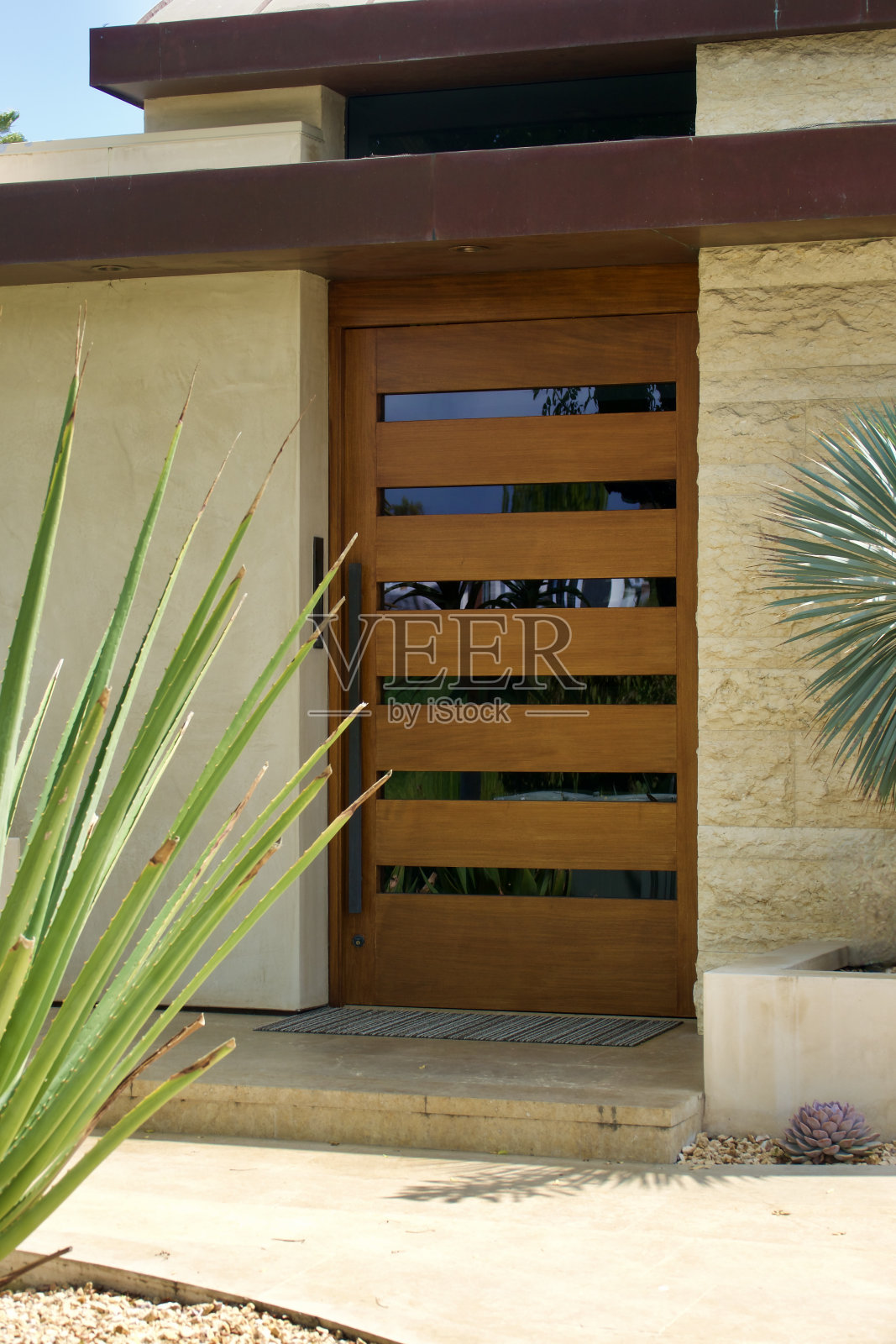 通往石灰岩建筑的现代柚木门照片摄影图片