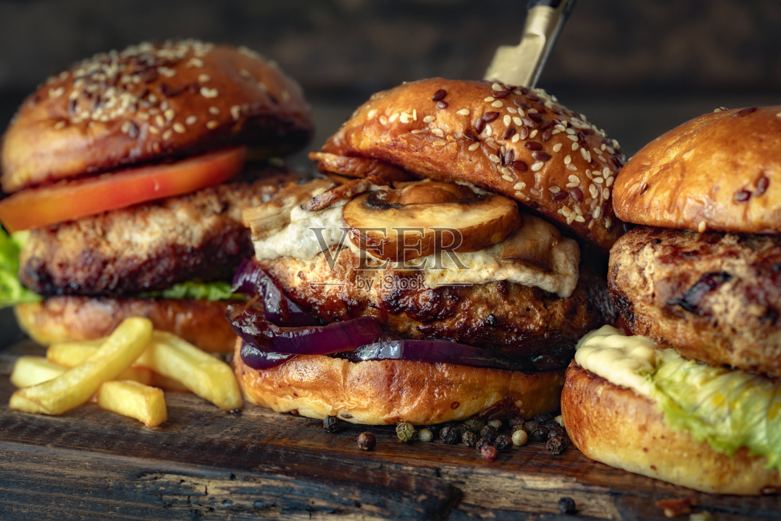 三个不同的残忍的汉堡放在木板上照片摄影图片