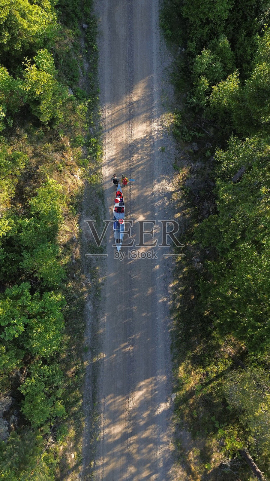 鸟瞰图,人们推着船沿着一条泥泞的小路穿过公园照片摄影图片