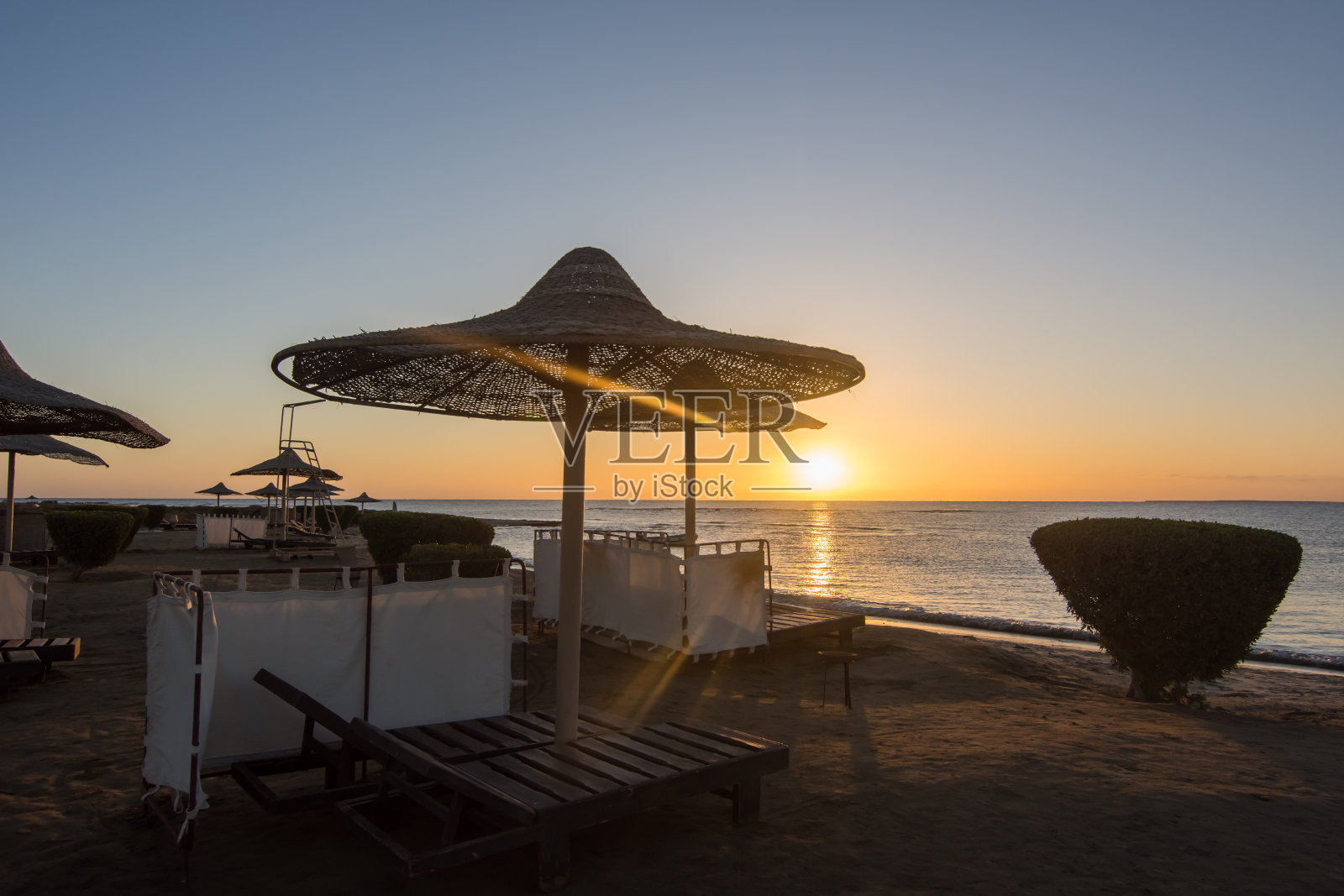 海边的沙滩伞和日出时的蓝天照片摄影图片