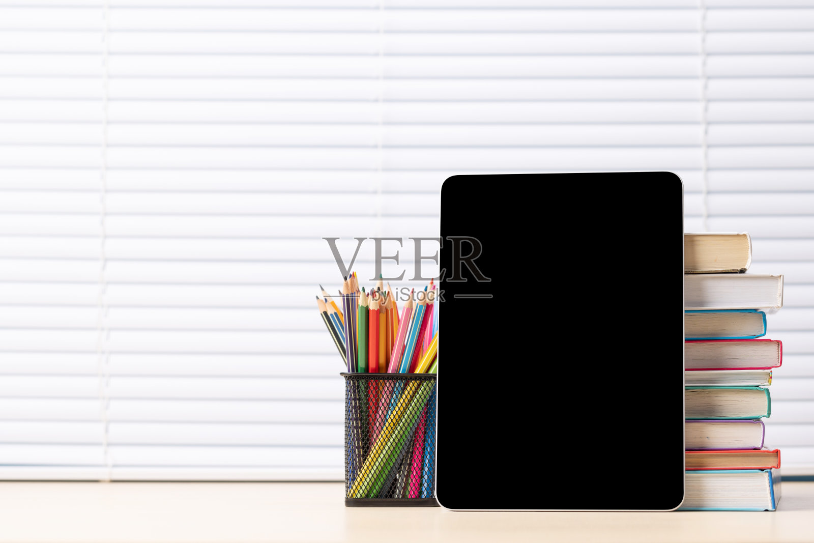 有彩色铅笔和一摞书的平板电脑照片摄影图片