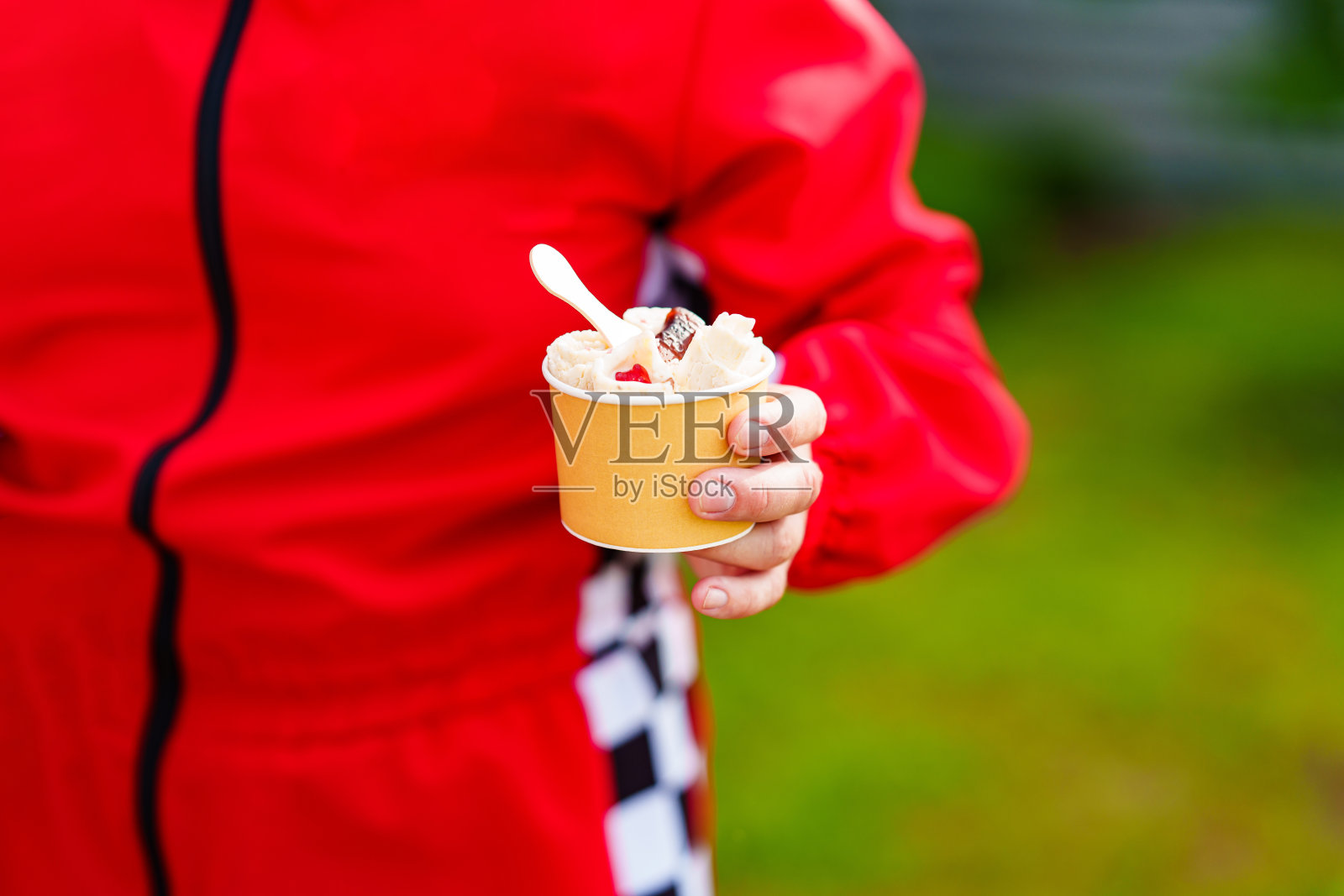 一杯冰淇淋滚在你的手中在街上。照片摄影图片