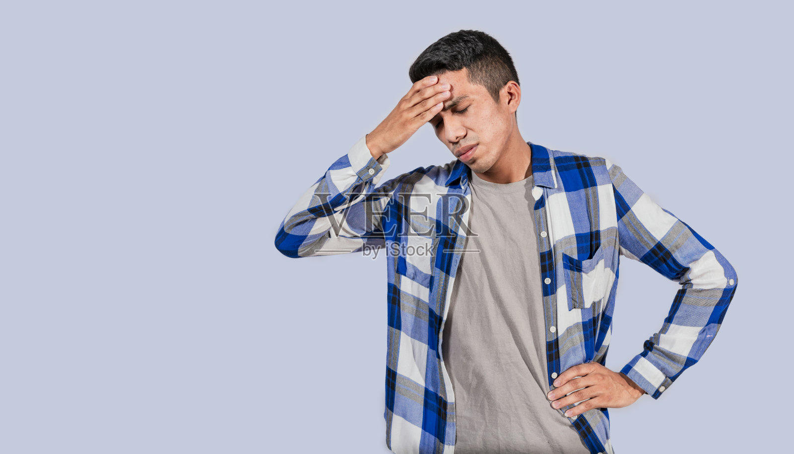 忧虑的年轻人捂着额头,忧虑的人孤立无援,疲惫的人捂着头,头痛的人照片摄影图片