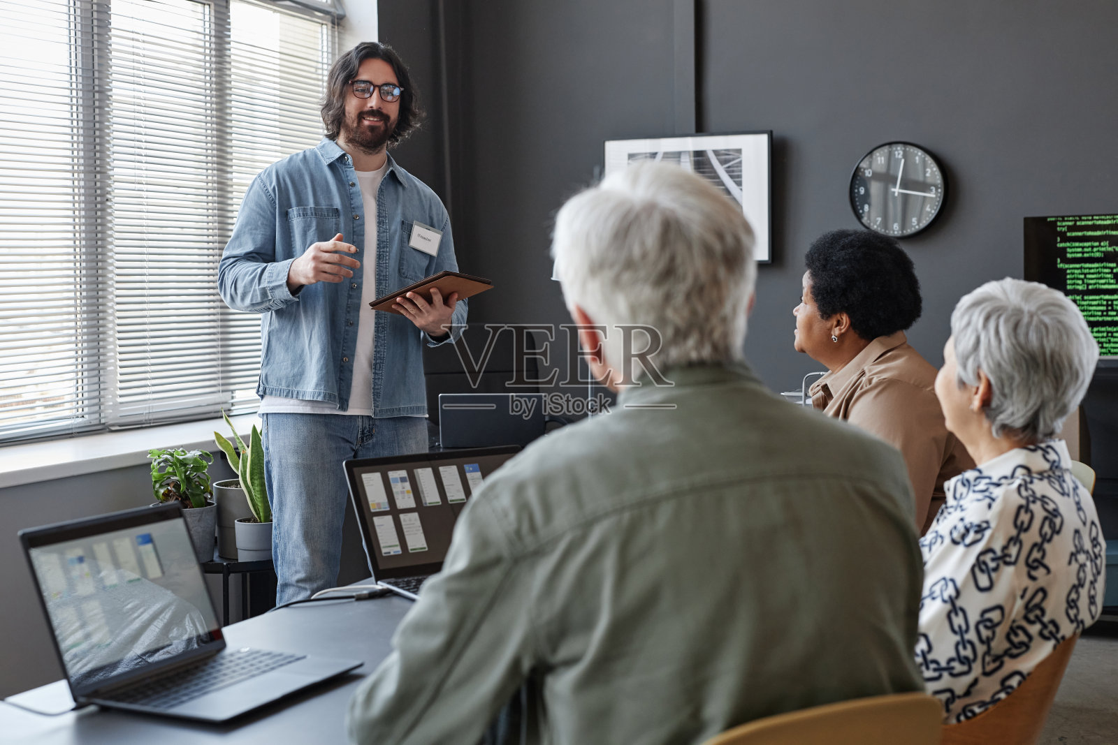 面带微笑的大胡子男子在给老年人上IT电脑课照片摄影图片
