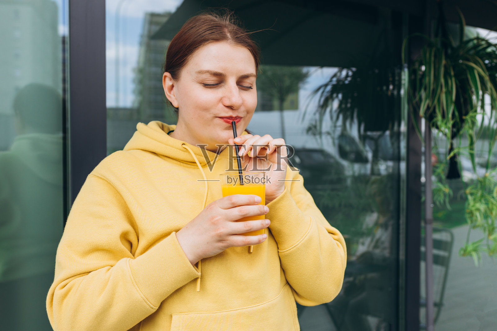 喝健康的橙汁,年轻的红发女运动员在锻炼后喝一杯新鲜的橙汁照片摄影图片