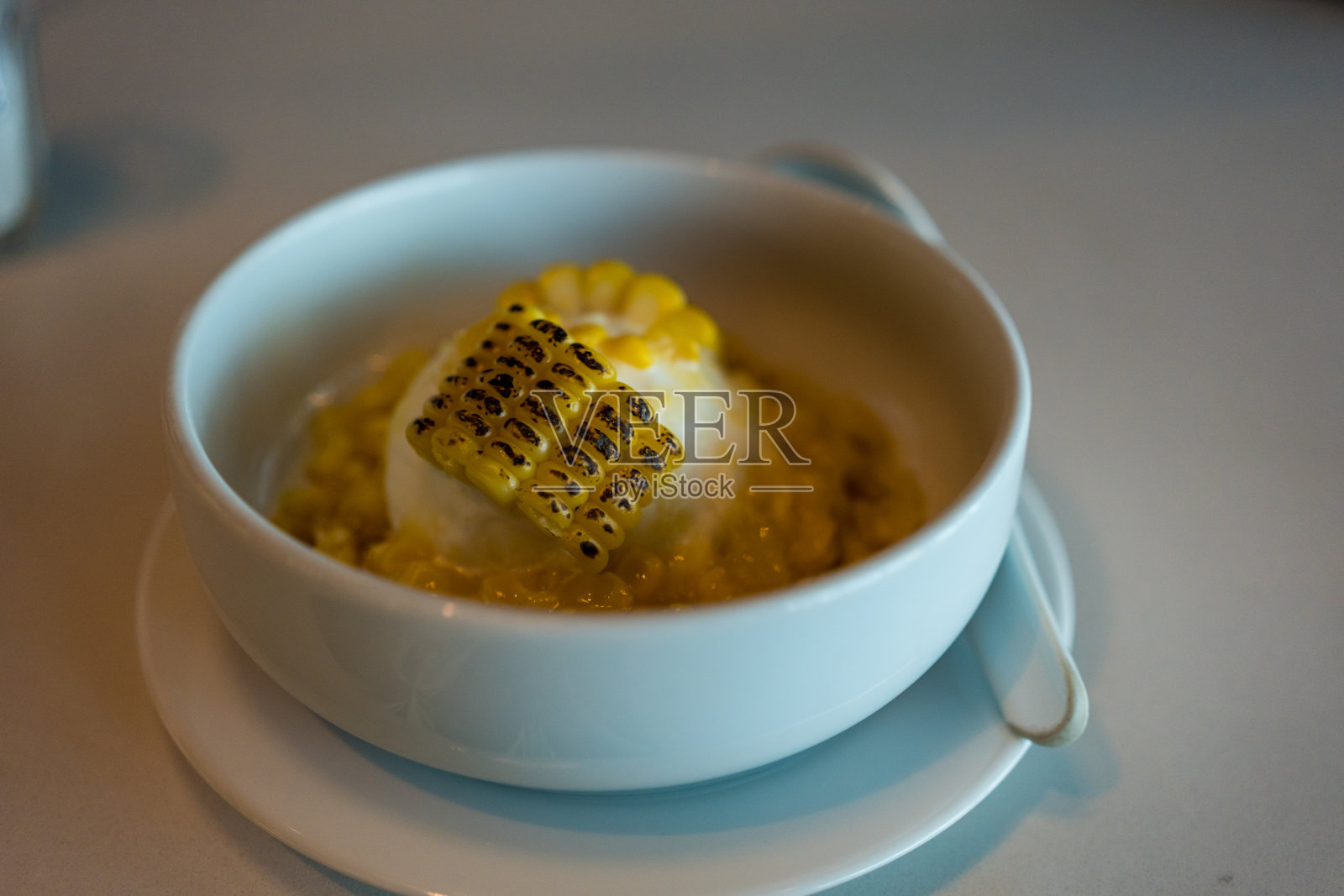 白碗上的烤甜玉米和香草冰淇淋照片摄影图片