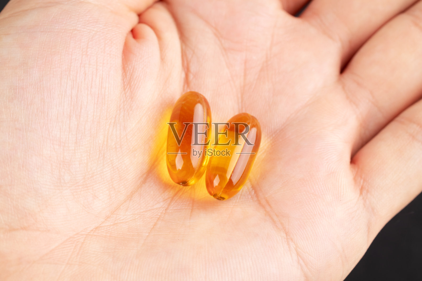 鱼油欧米茄3凝胶胶囊在黑色背景,特写照片摄影图片