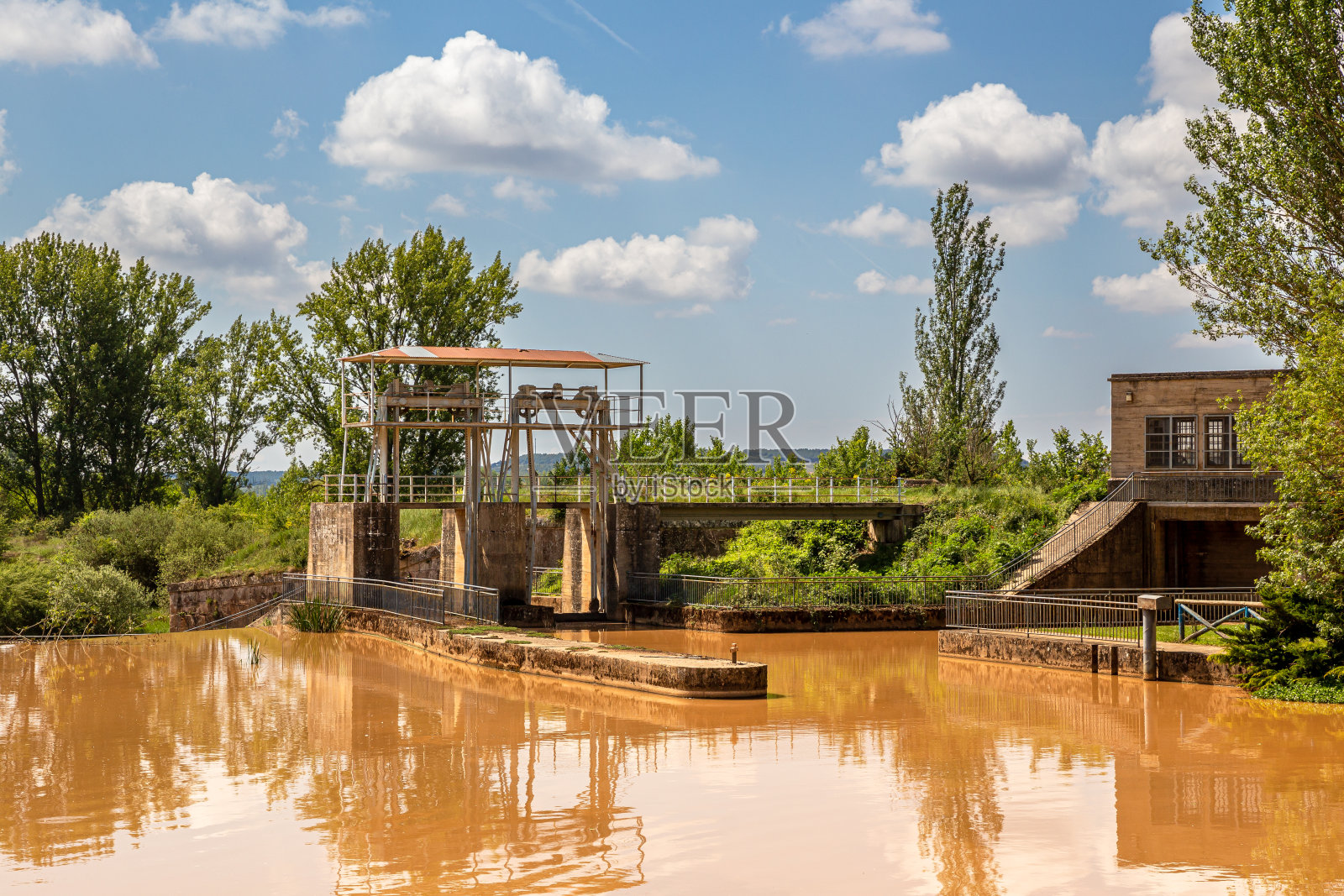 近距离观看卡斯蒂利亚运河圣安德烈斯大坝的大门与多云的水在阳光明媚的日子,埃雷拉德皮苏尔加,帕伦西亚,西班牙照片摄影图片