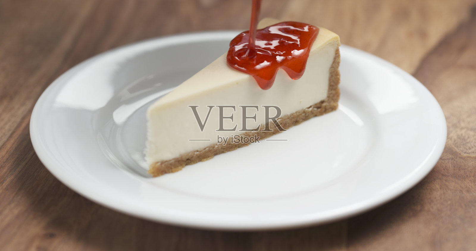 草莓酱浇在传统的纽约芝士蛋糕上照片摄影图片