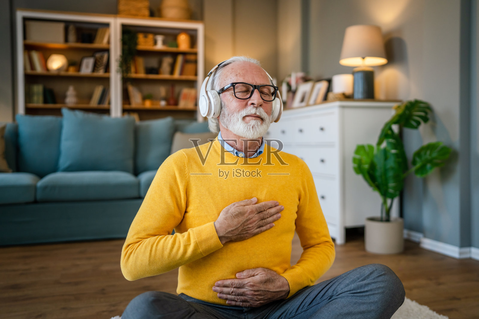 成熟的老年男子在家练习引导冥想的表现照片摄影图片