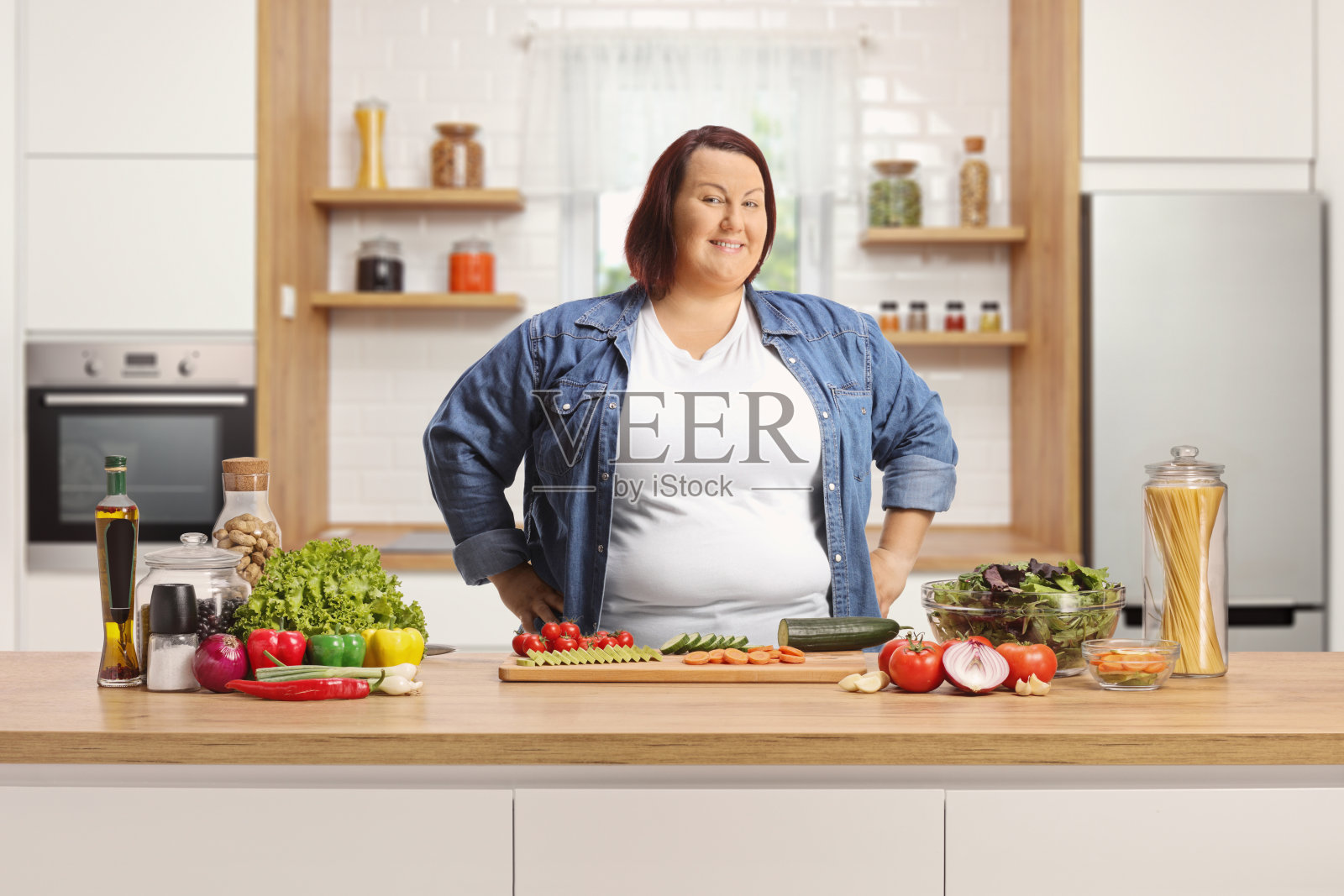 一个胖女人拿着健康食品在柜台后面摆姿势照片摄影图片