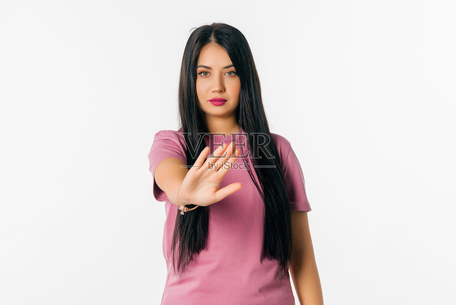 年轻的黑发女子穿着休闲夏季t恤在白色孤立的背景做停止手势手掌。一脸严肃的警告表情照片摄影图片