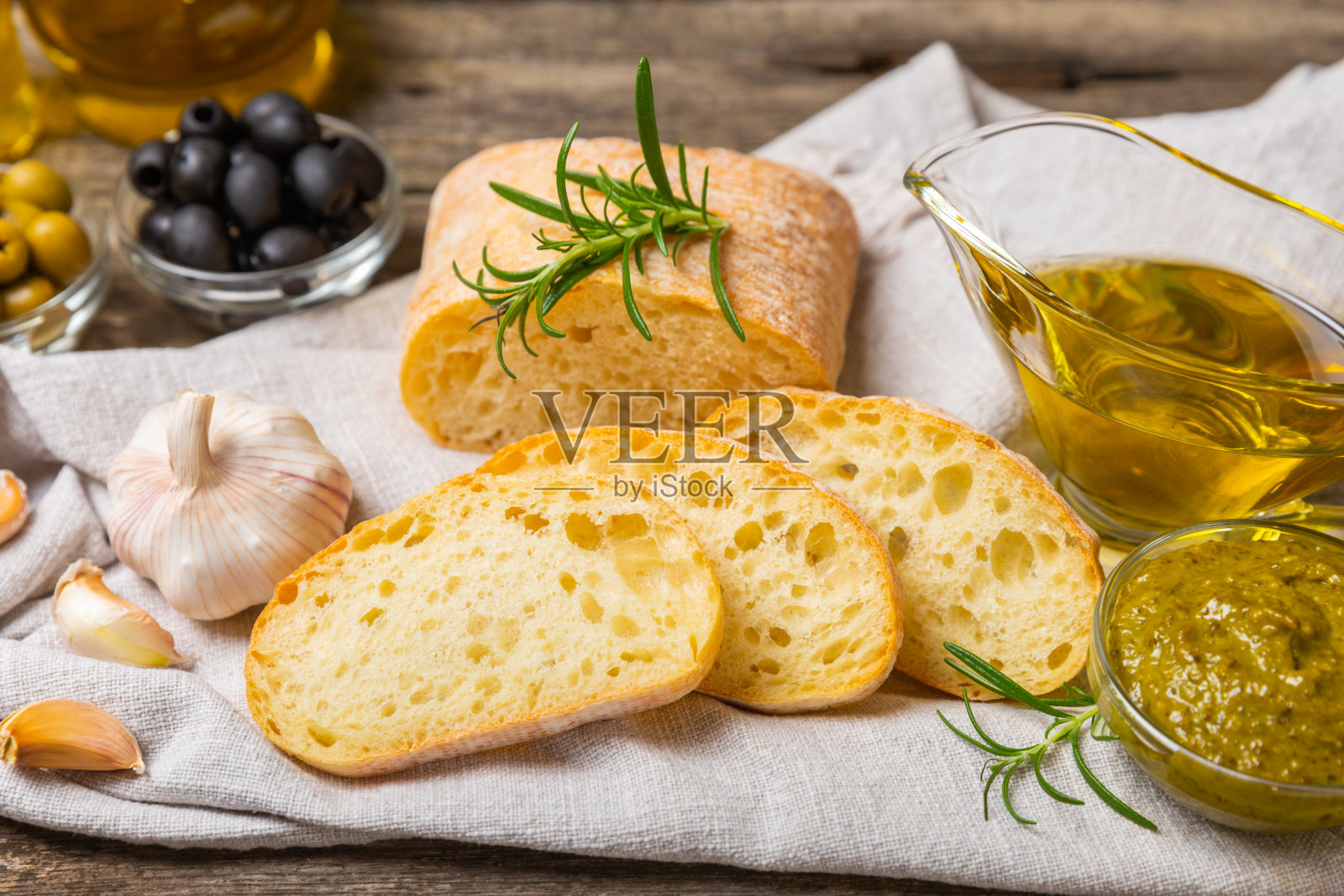 ciabatta,一碗橄榄油,配上橄榄、香草、香料、大蒜、香蒜酱、帕尔马干酪和ciabatta面包。健康食品理念,美味。地中海厨房。副本的空间。照片摄影图片