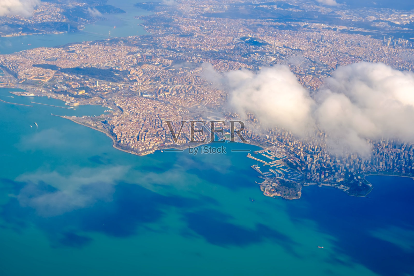 在晴朗的天气里,飞机在伊斯坦布尔上空飞行照片摄影图片