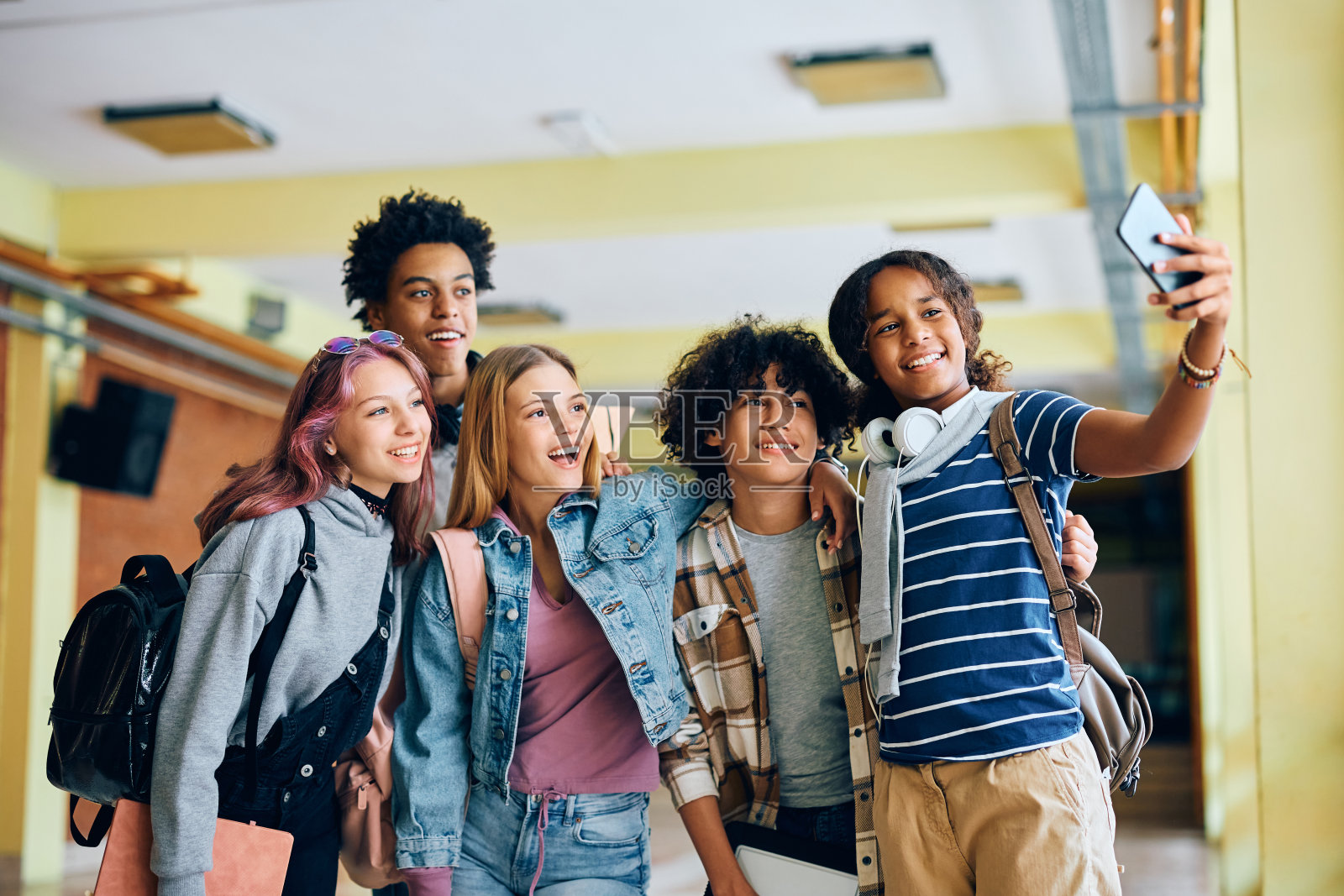 快乐的高中朋友们在用智能手机自拍时玩得很开心。照片摄影图片