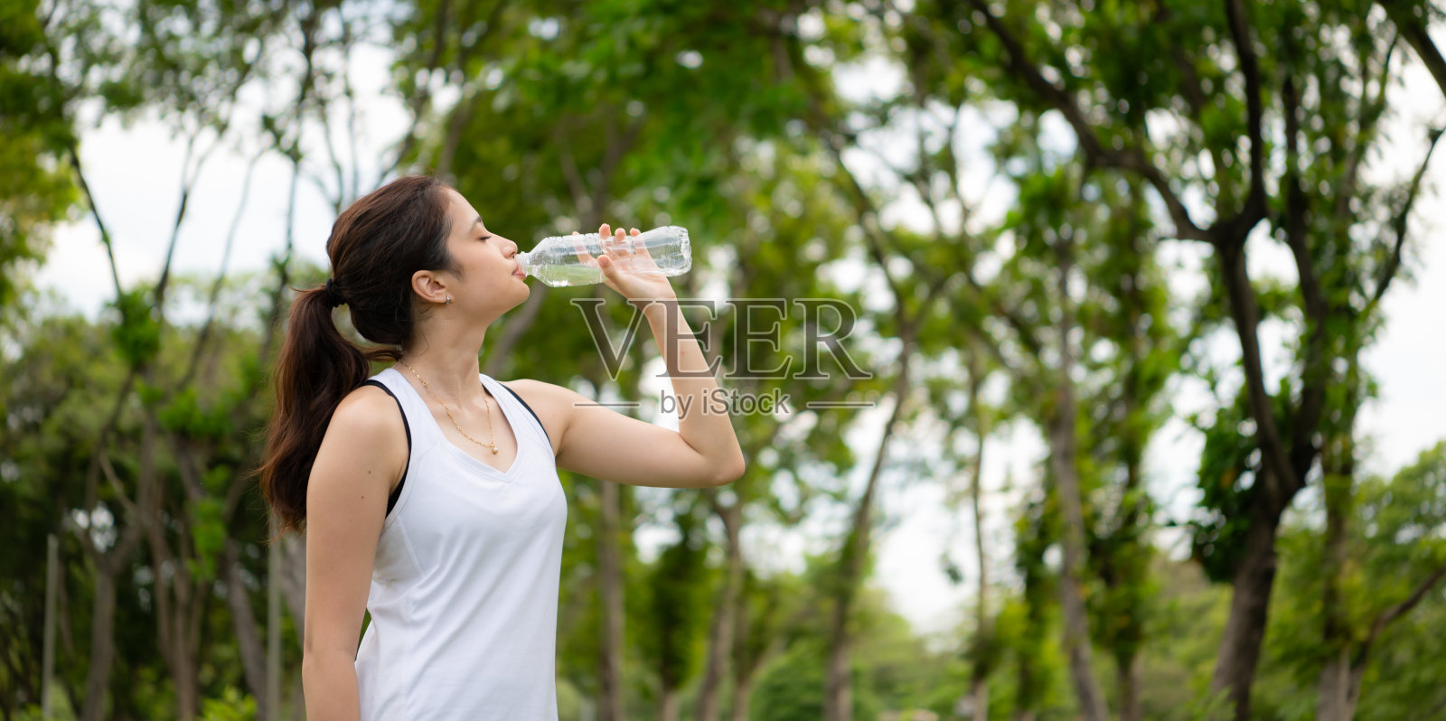 年轻女性在城市公园进行户外活动,瑜伽是她选择的活动。照片摄影图片