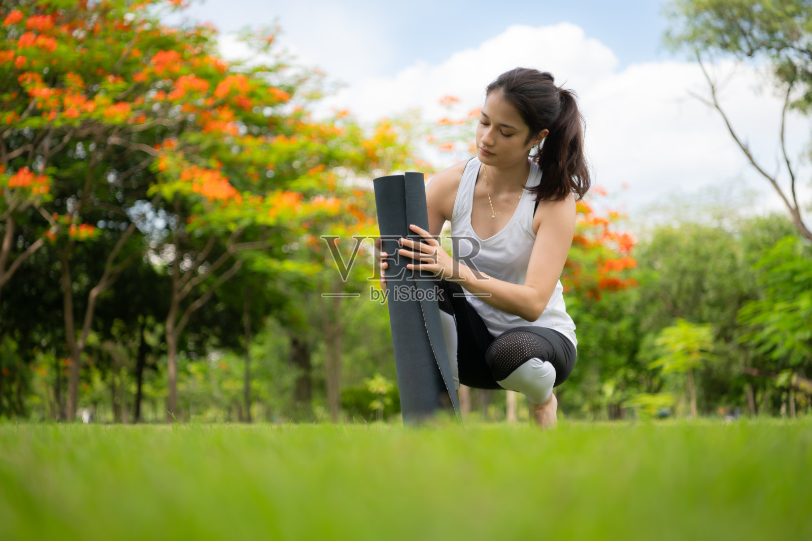 年轻女性在城市公园进行户外活动,瑜伽是她选择的活动。照片摄影图片