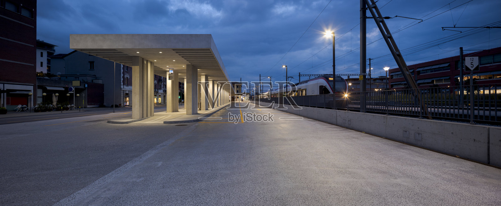 现代公交车站候车亭,旁边是门德里西奥火车站。瑞士的现代基础设施照片摄影图片