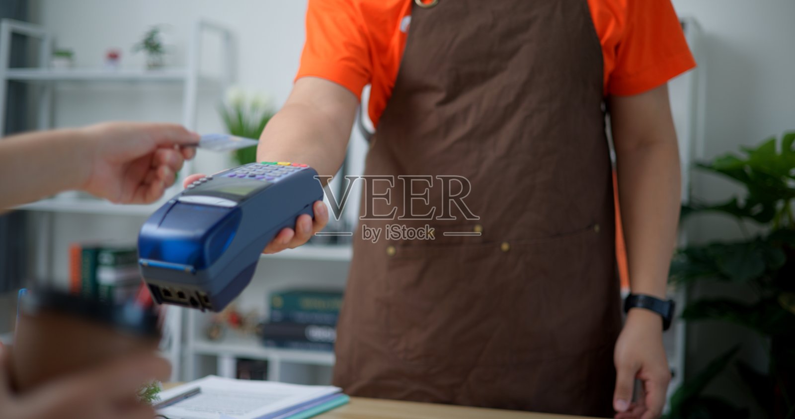 使用NFC技术的非接触式信用卡支付的顾客之手照片摄影图片