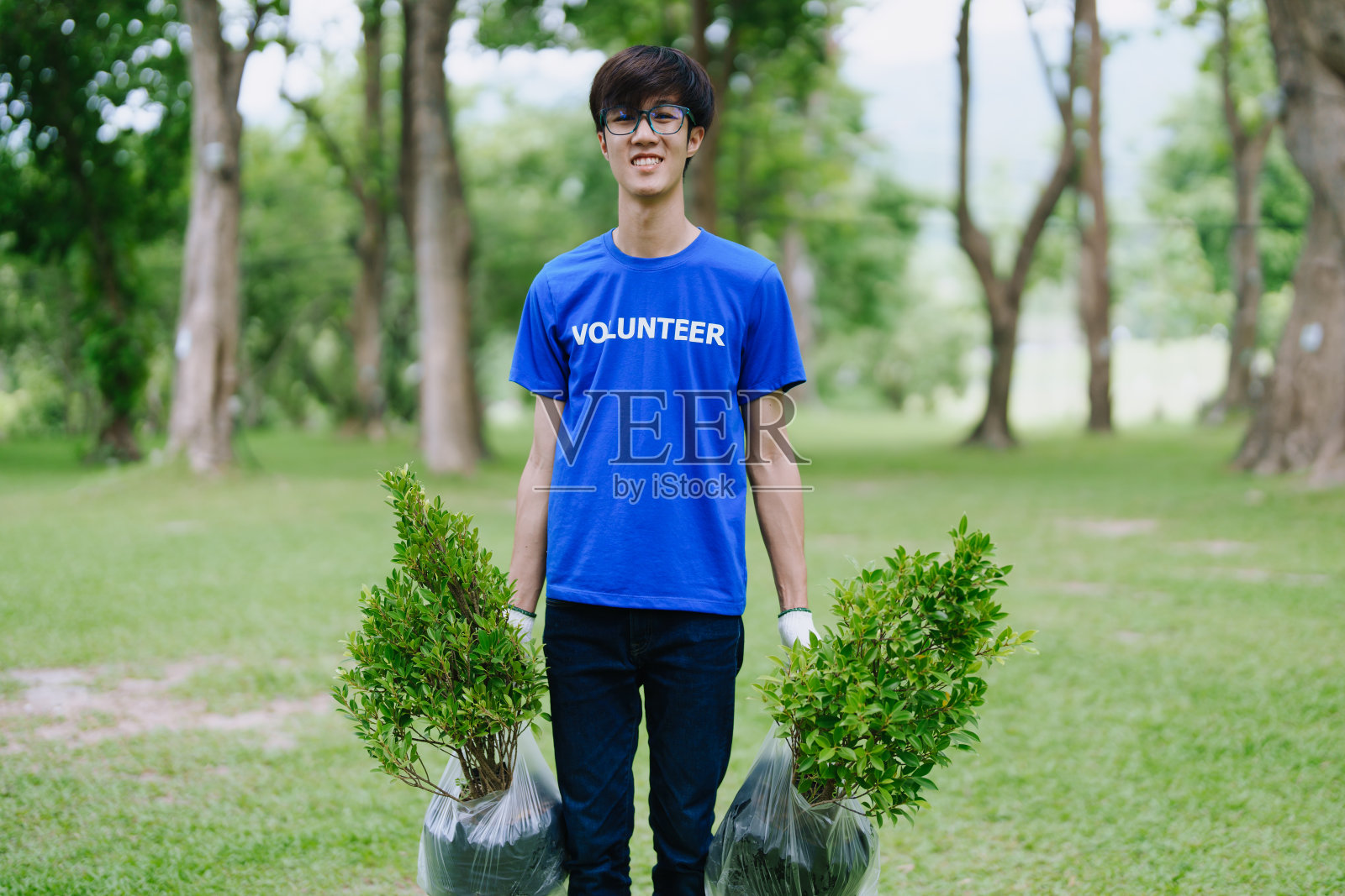 为了减少空气中的二氧化碳,各国志愿者们牺牲自己的时间,植树造林,恢复自然,表现出团结一致的精神。照片摄影图片