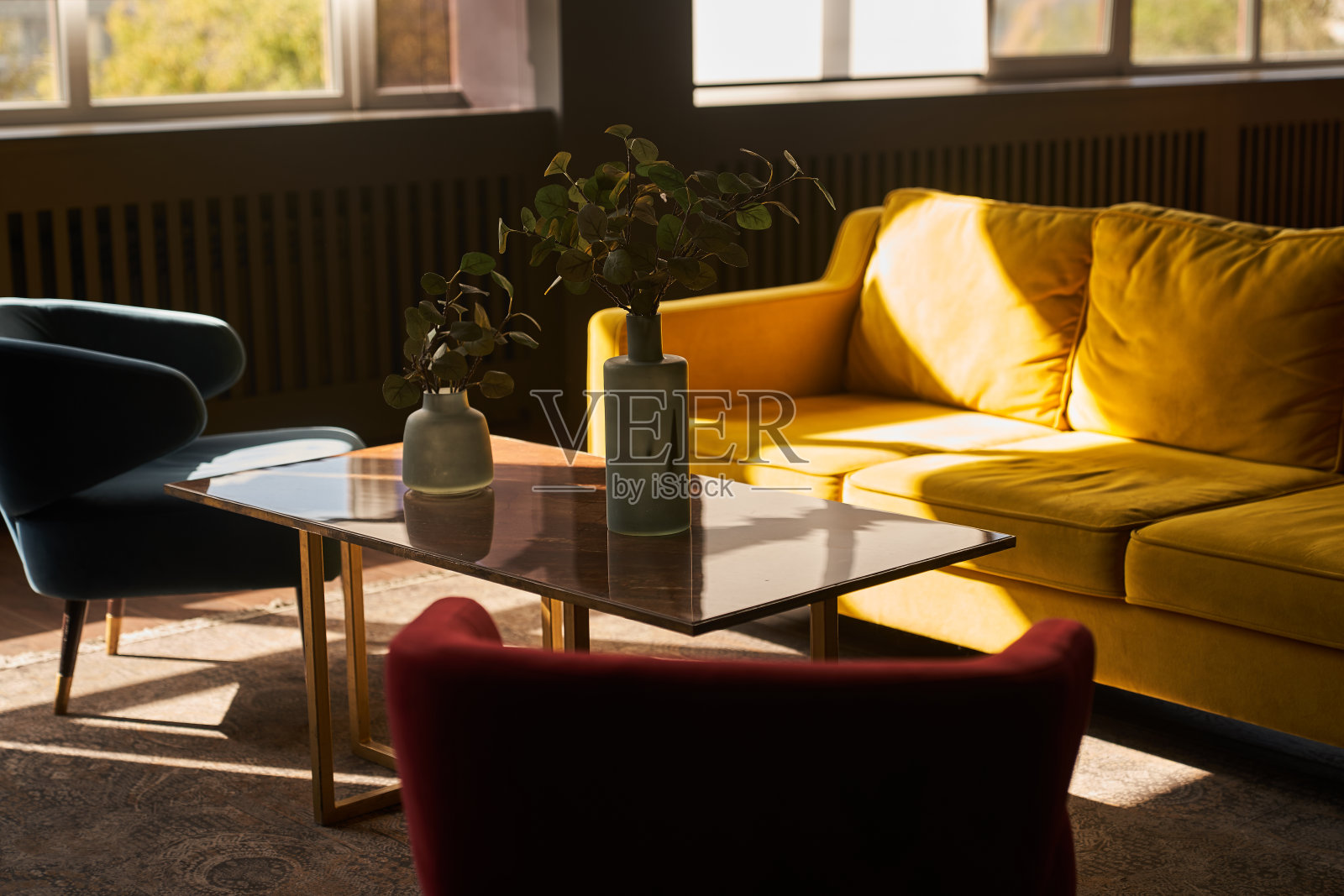 室内的开放空间配有设计师模块化的黄色沙发、咖啡桌、热带植物中优雅时尚的花瓶。现代客厅。高质量照片照片摄影图片