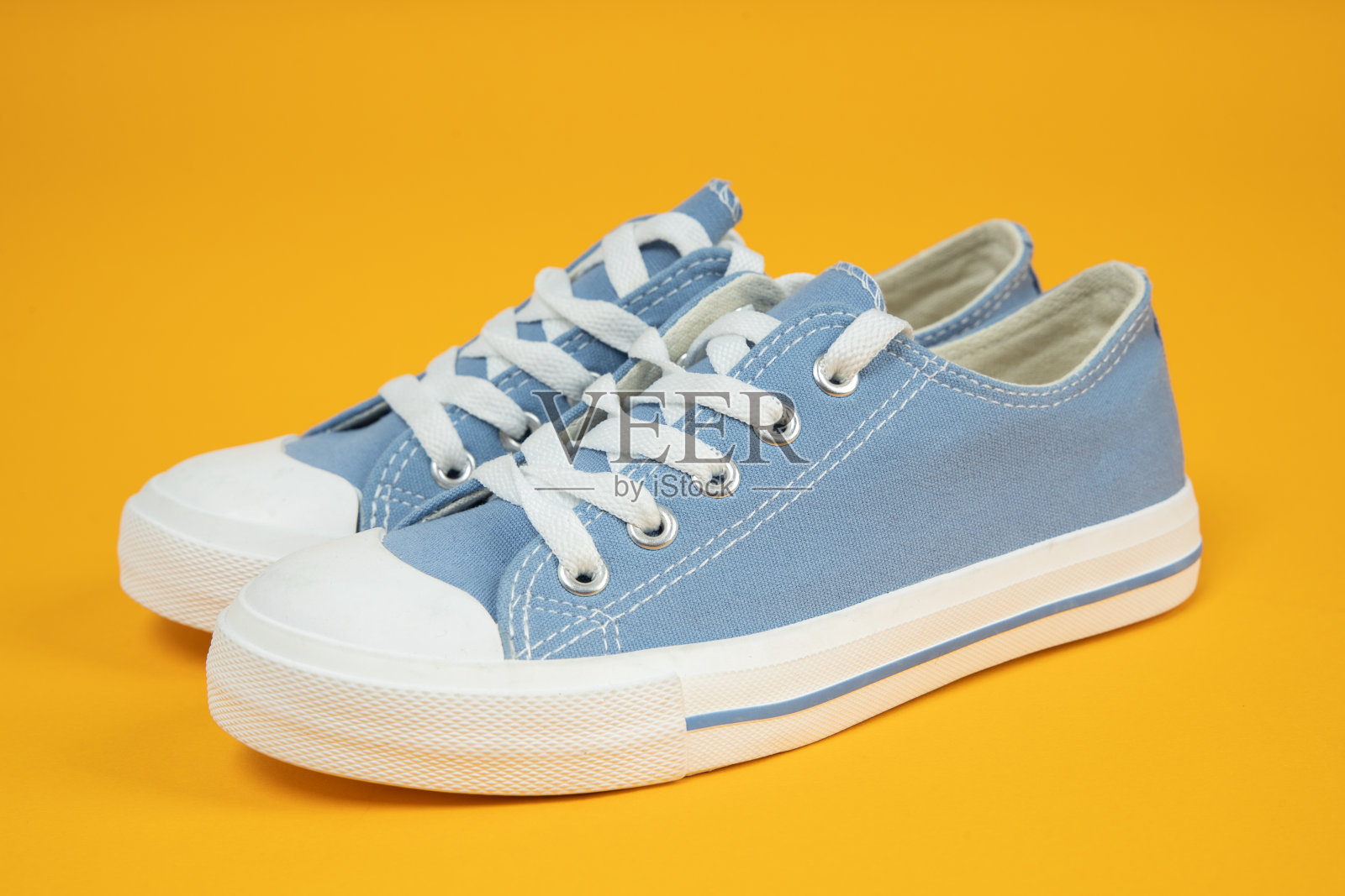 一双新的蓝色运动鞋,黄色底运动鞋。照片摄影图片