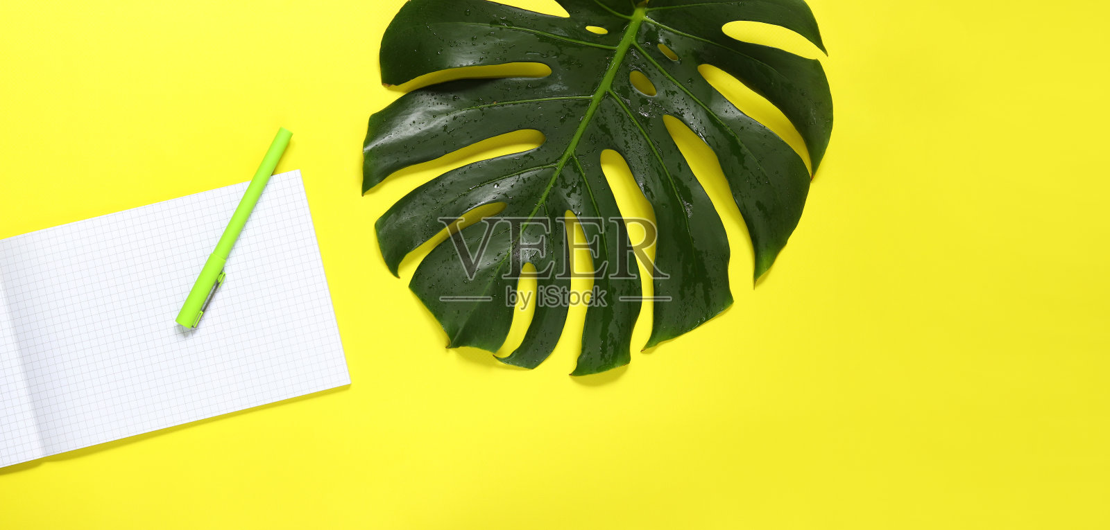 打开记事本,钢笔和怪物纸在一个黄色的背景照片摄影图片