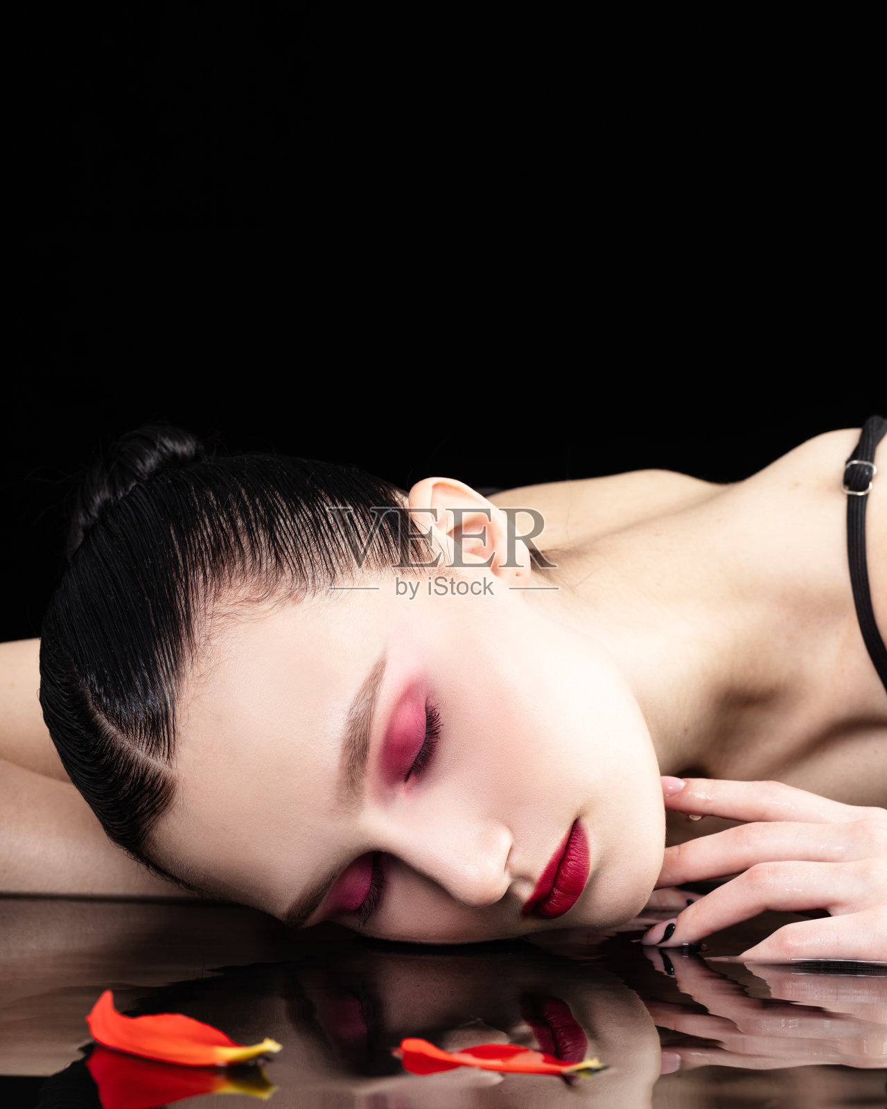 美丽,性感,华丽的黑发女孩在黑暗的室内穿着黑色睡衣,在浴缸里扔玫瑰花瓣照片摄影图片