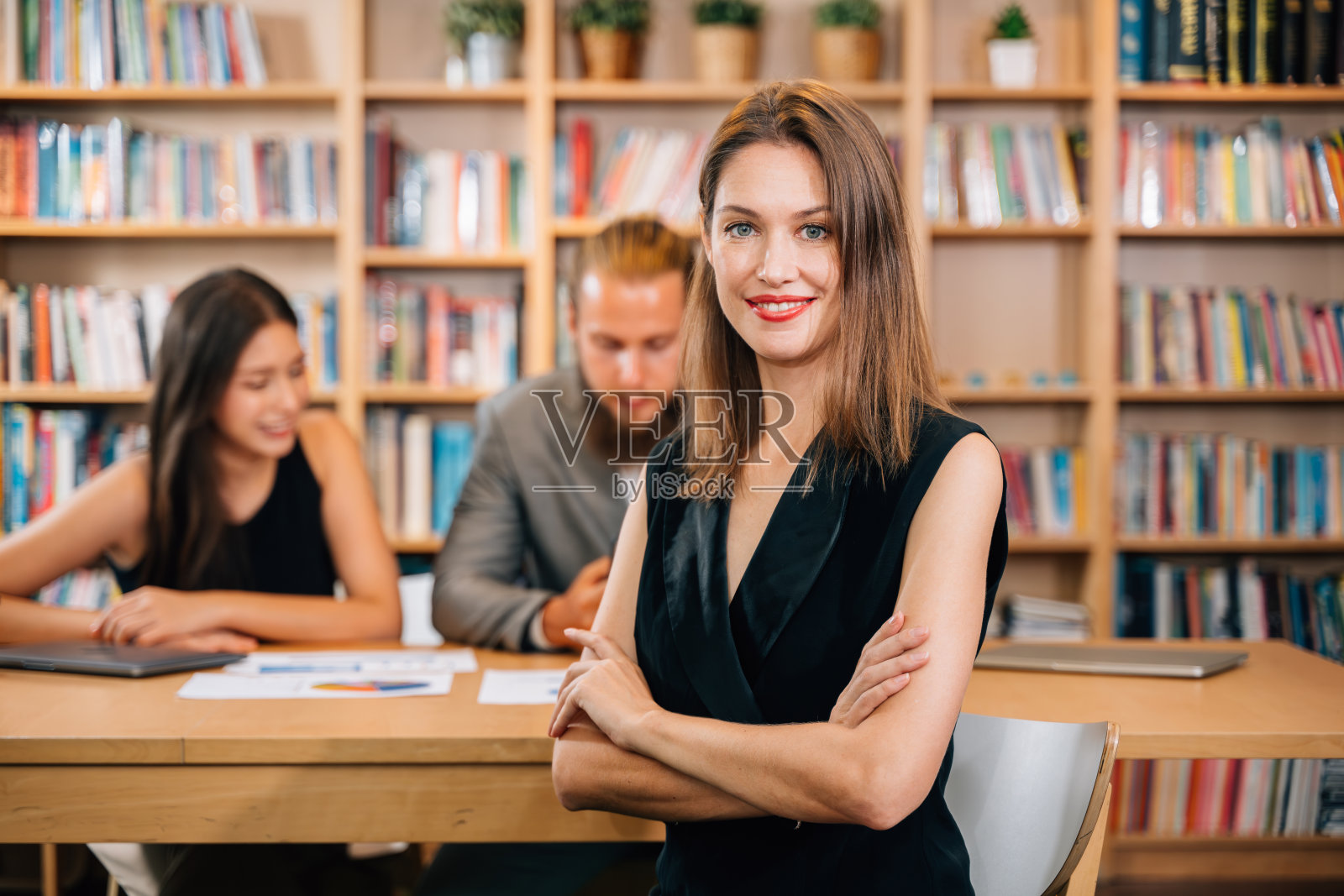 自信的女商人面带微笑,双臂交叉摆姿势照片摄影图片