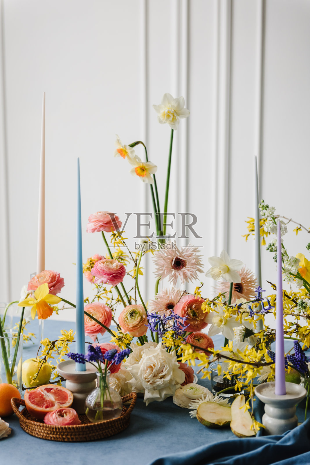 夏日花园花的构图。家庭度假在现代餐厅。用鲜花、水果、绿色植物和蜡烛装饰的节日餐桌。生日庆祝活动。时尚的春季派对。家庭内部。照片摄影图片