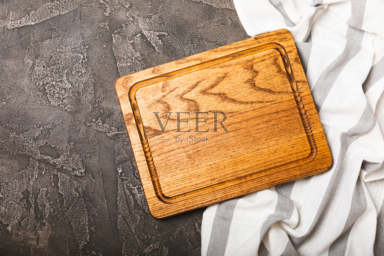 厨房黑色桌子上的空木板。砧板和厨房毛巾。木制砧板,复印空间。厨房用具。配方。放文字的地方。平的。照片摄影图片