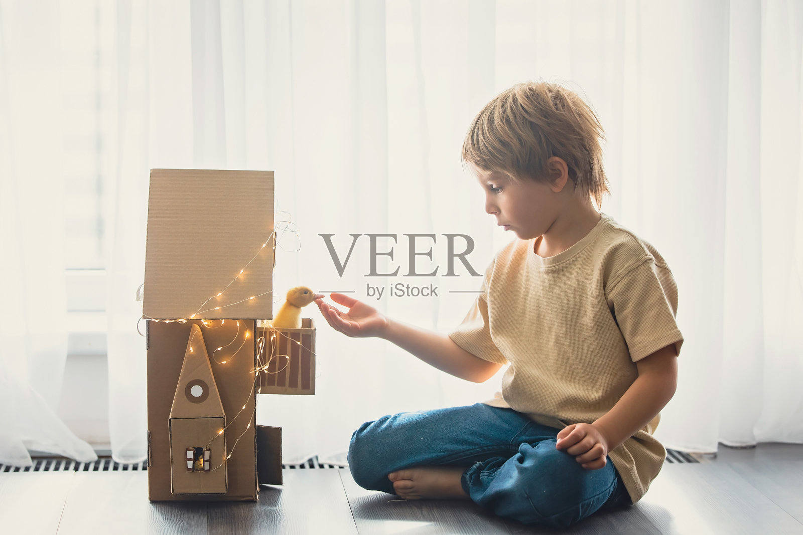 快乐的美丽的孩子们,玩着美丽的小鸭子,可爱的毛绒绒的动物小鸟照片摄影图片