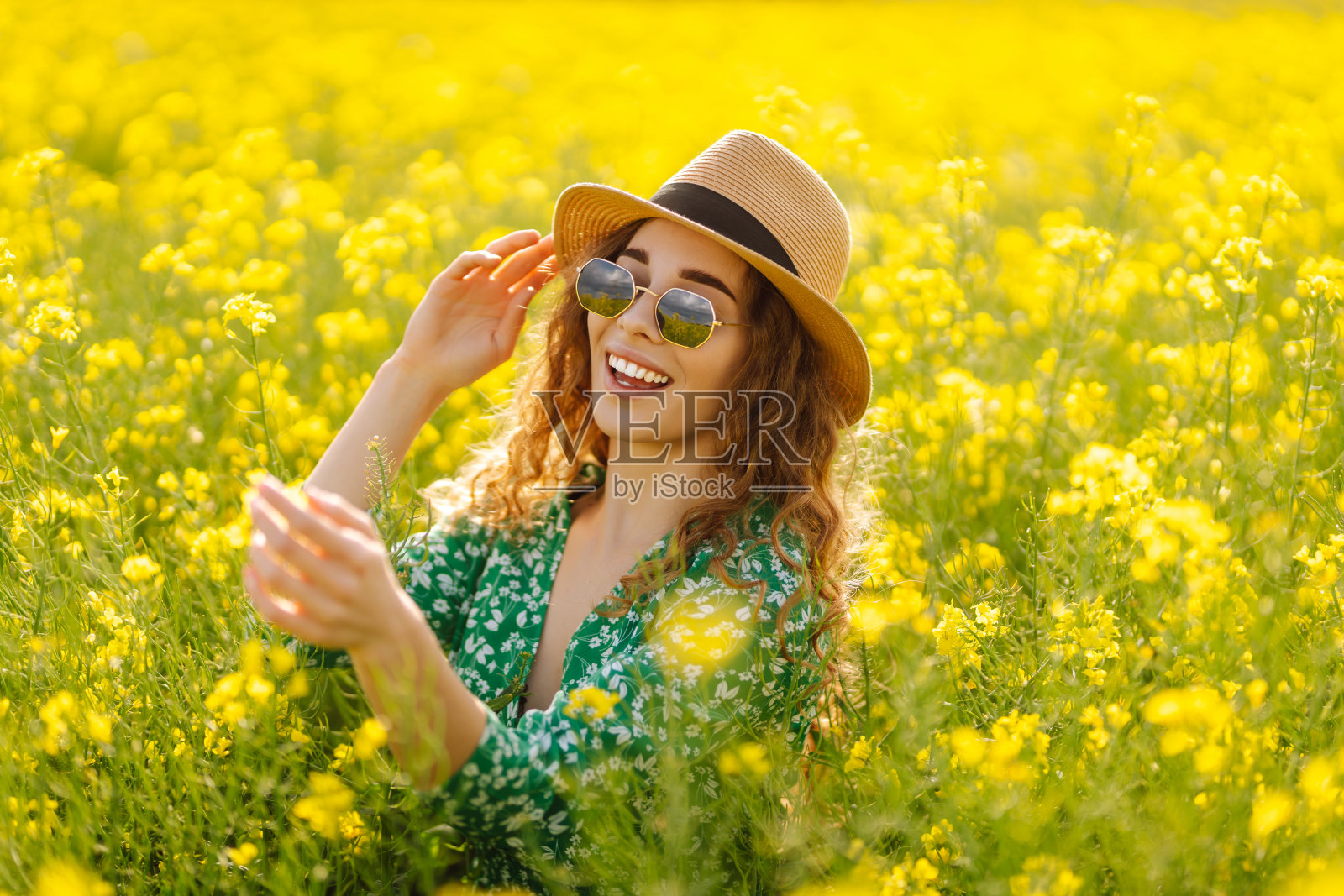 美丽的女人在盛开的田野里。照片摄影图片