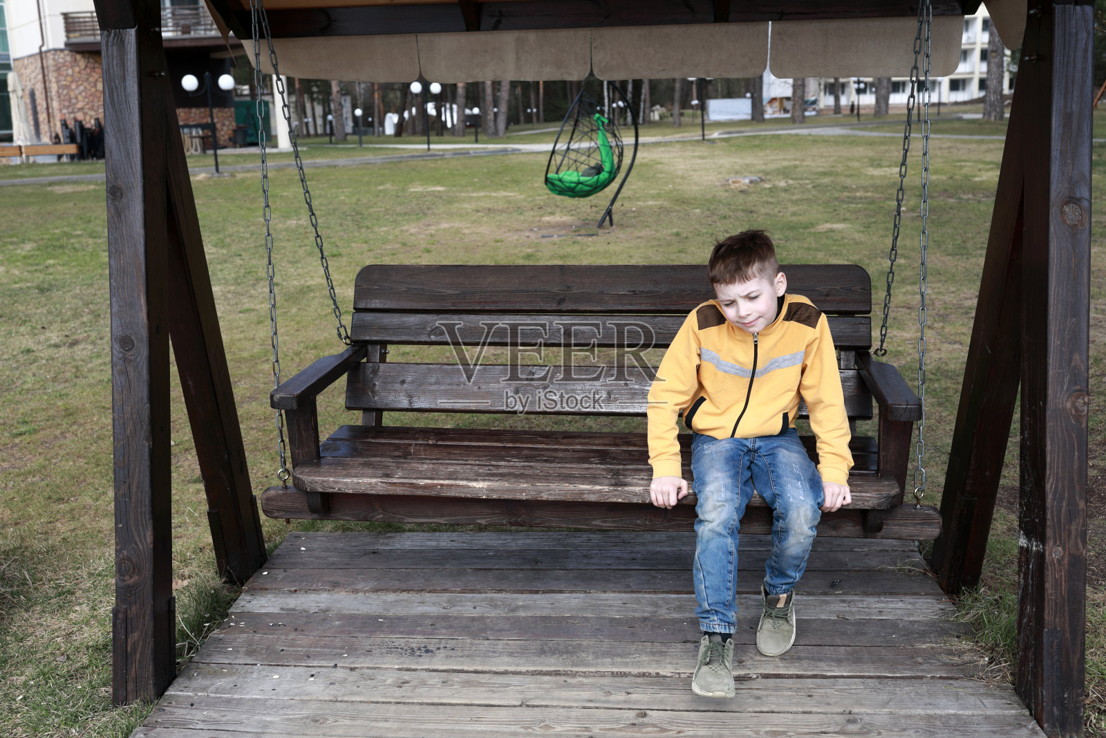 孩子在悬挂的木凳上休息照片摄影图片
