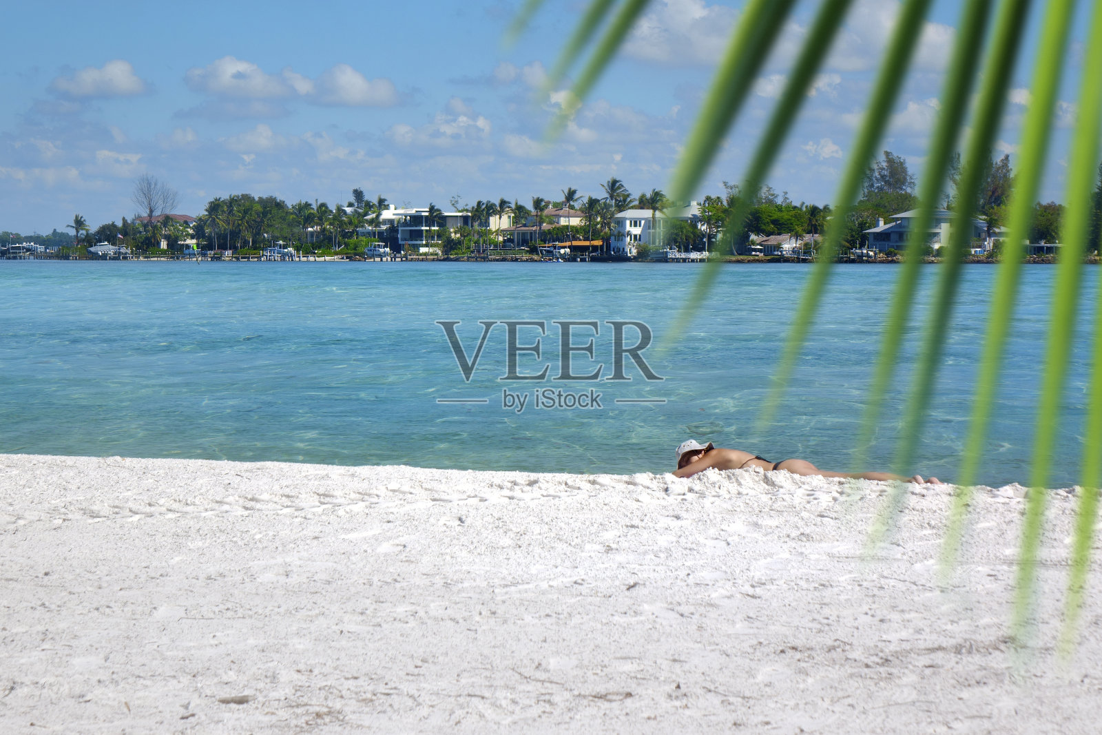 穿着比基尼的单身女子在白色的热带沙滩上晒日光浴照片摄影图片