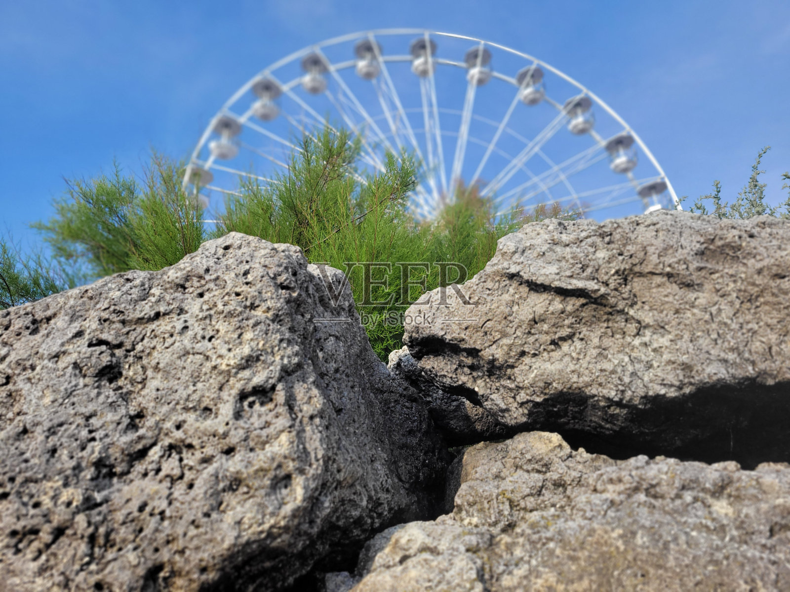 岩石后面的摩天轮照片摄影图片