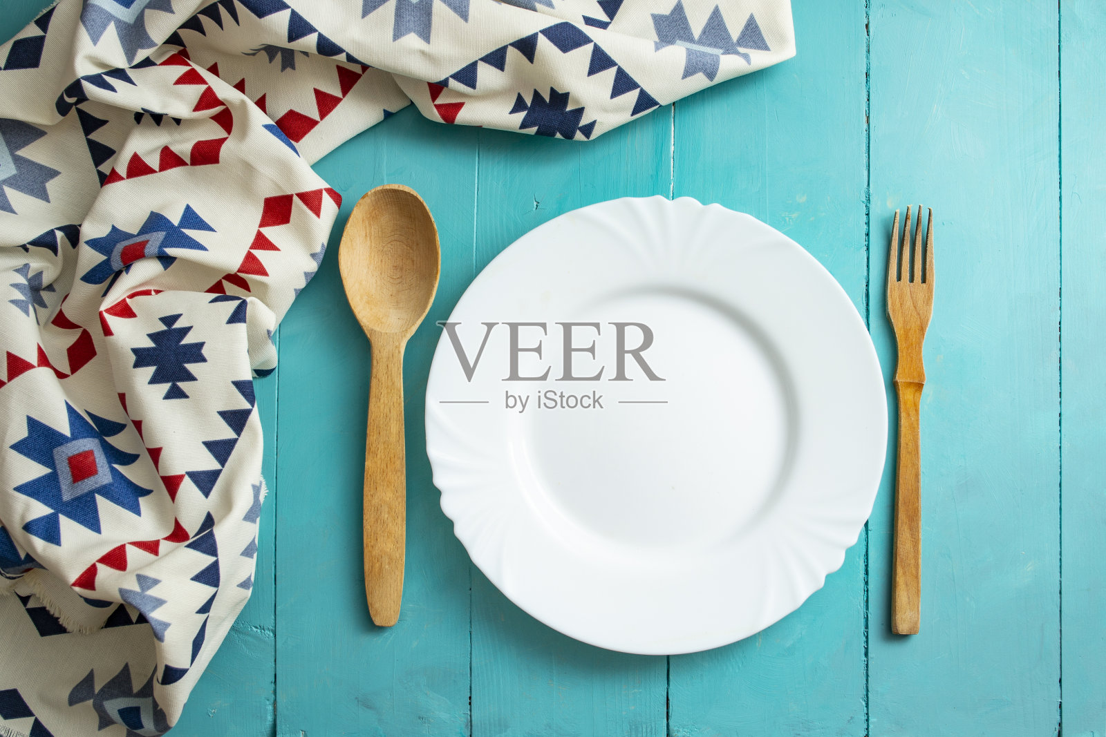 白色的空盘子上有木制餐具和罗马尼亚民族图案的餐巾照片摄影图片
