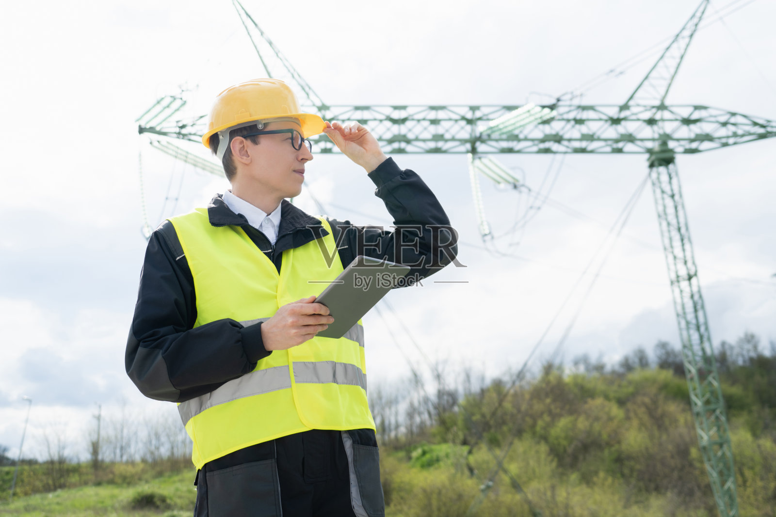 有电力线塔背景的工程师。照片摄影图片