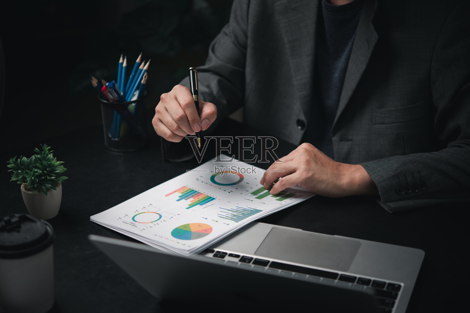 手提电脑手持笔金融创业图表文档。业务投资增长分析战略规划数据分析营销概念。照片摄影图片