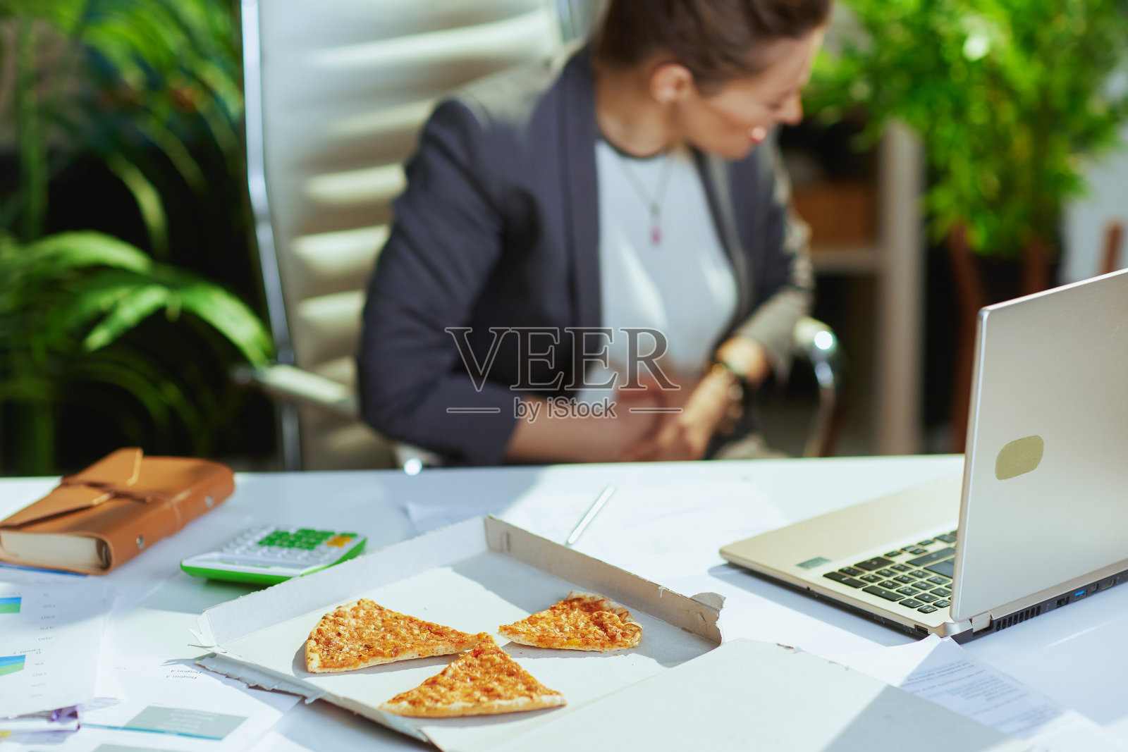 绿色办公室的现代女记账员胃痛照片摄影图片