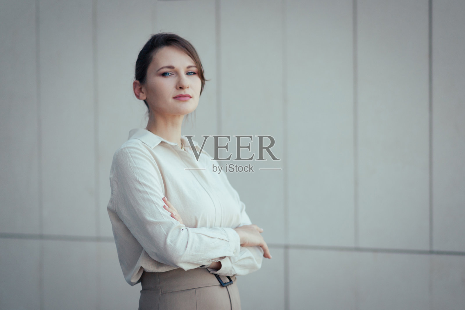 肖像的年轻严肃的商业妇女看着相机与交叉的手臂与复制空间照片摄影图片