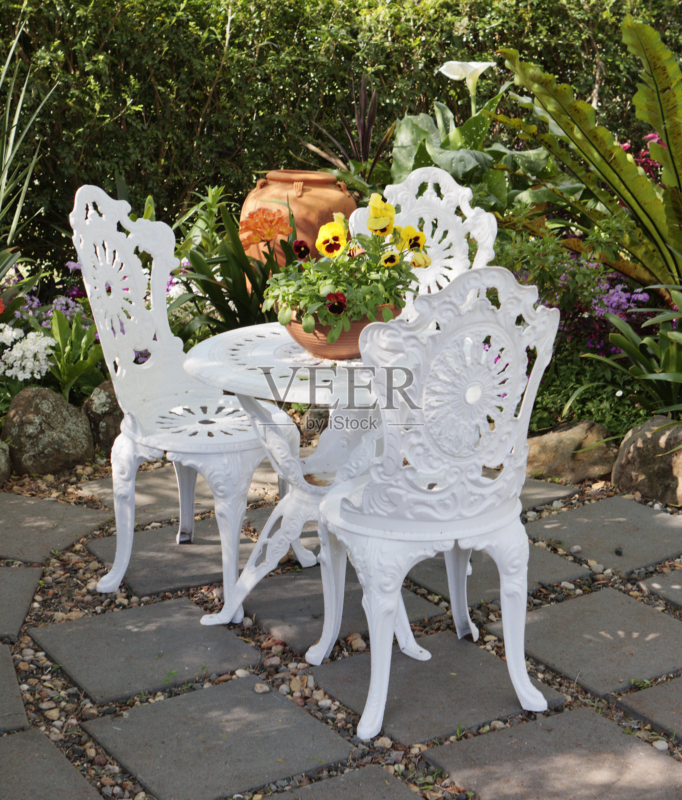 带有三色堇盆栽的花园家具照片摄影图片