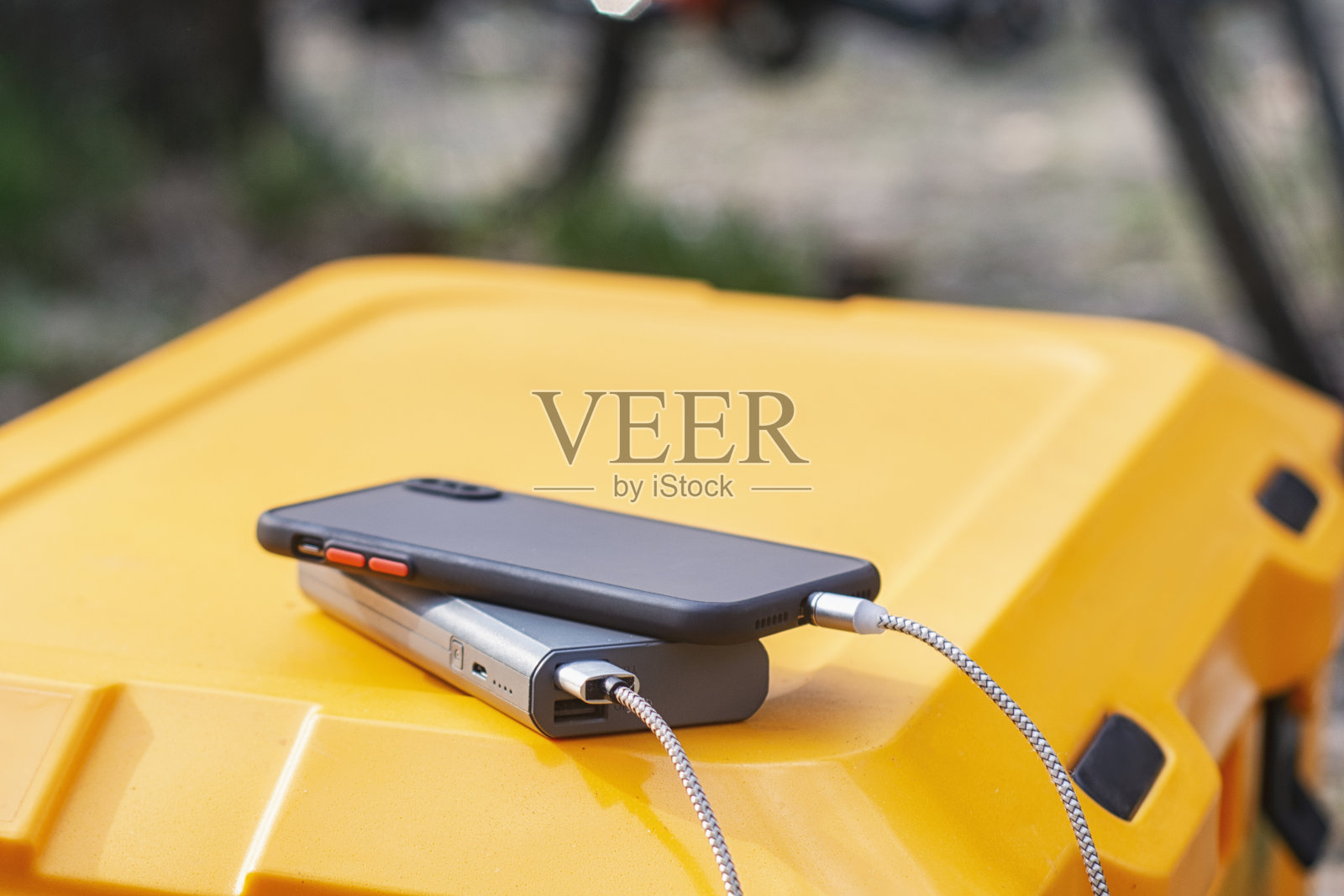 Powerbank以自然中的自行车为背景,在游客的冰箱上为智能手机充电。关于旅游和旅游主题的概念。照片摄影图片