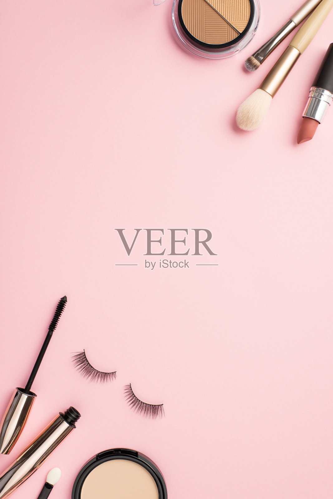 化妆的概念。俯视图垂直照片的轮廓调色板口红假睫毛化妆刷睫毛膏和粉盒粉彩粉红色的背景与copyspace照片摄影图片