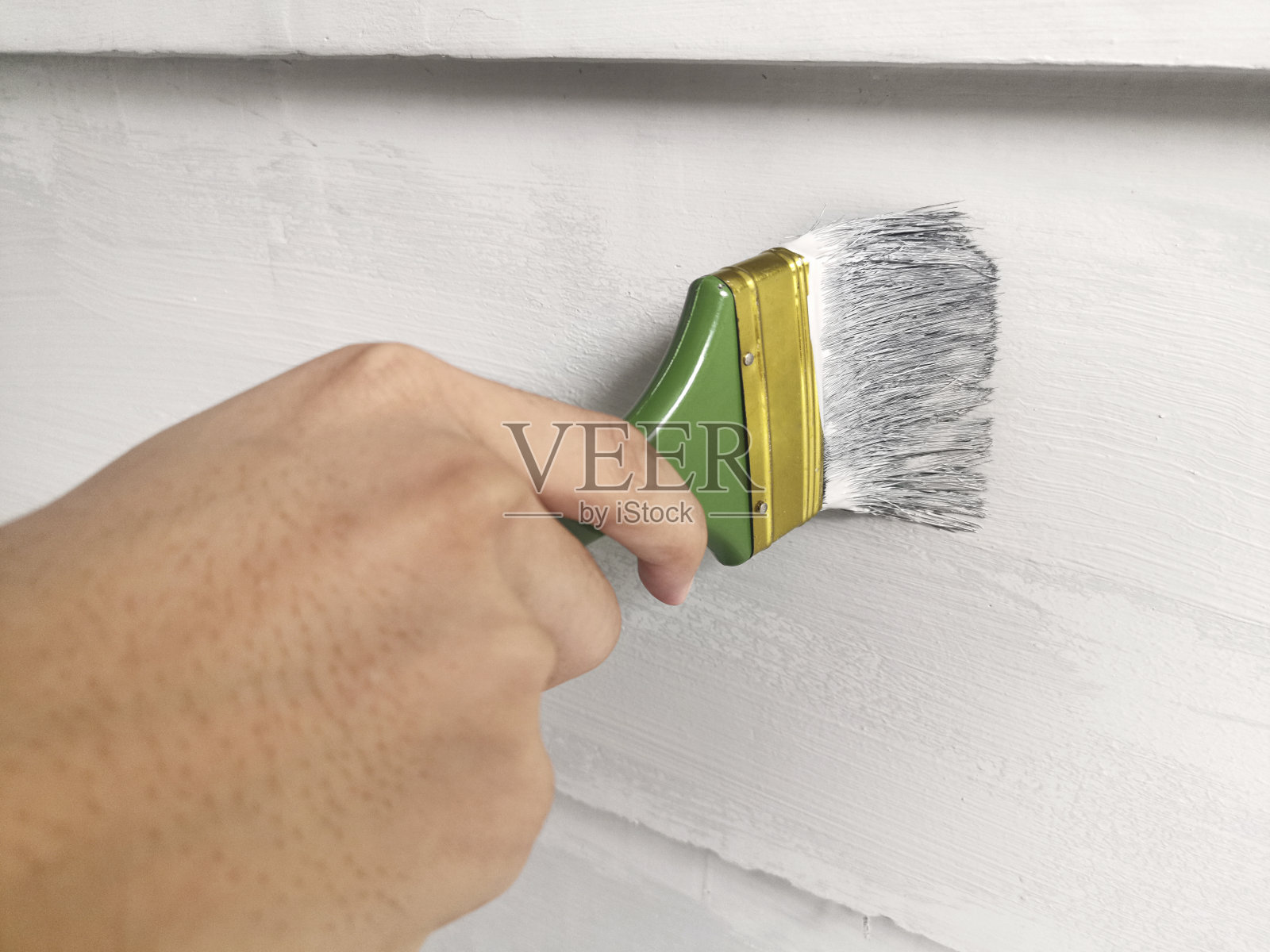 手握画笔画墙照片摄影图片