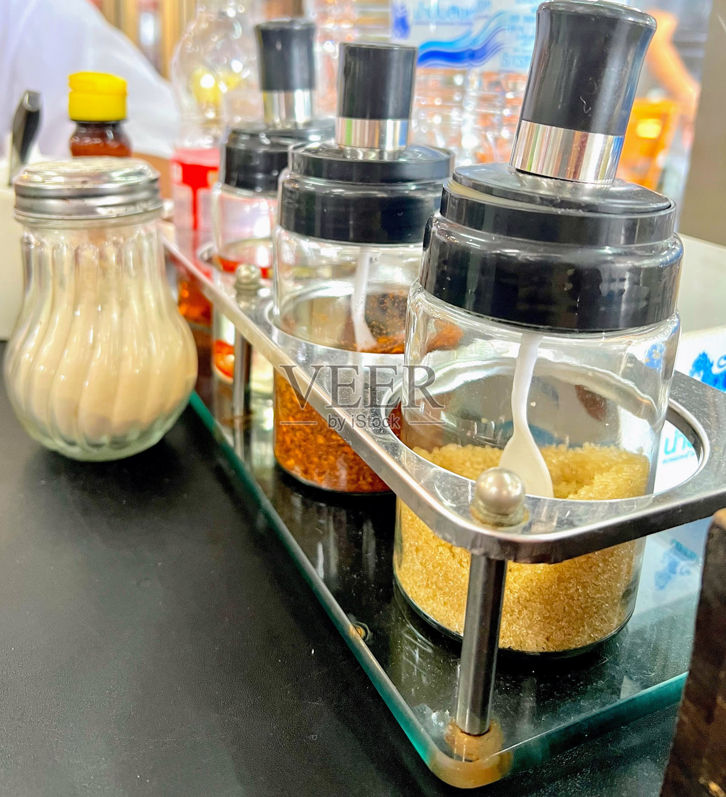 一张摆满各种香料和调味品的柜台的照片,柜台上的坛子里有许多不同的香料照片摄影图片