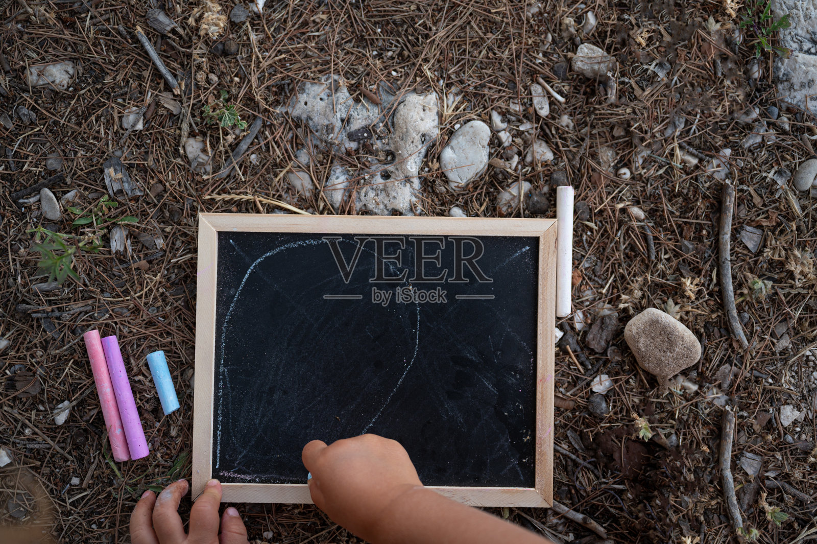 孩子用粉笔在小黑板上画画的俯视图照片摄影图片