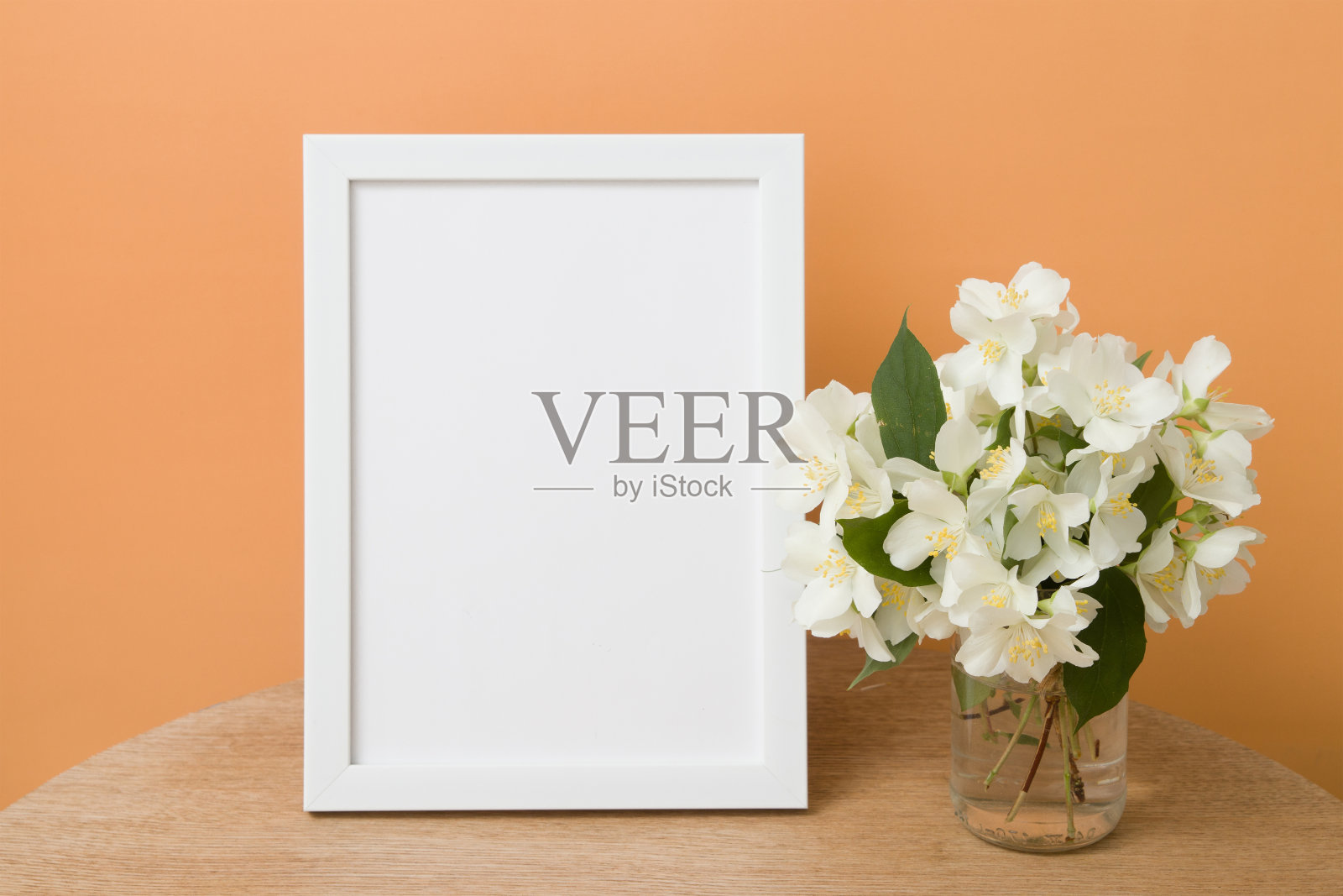 模拟在一个圆桌上与茉莉花在橙色背景空白色框架。放置文本或图像照片摄影图片