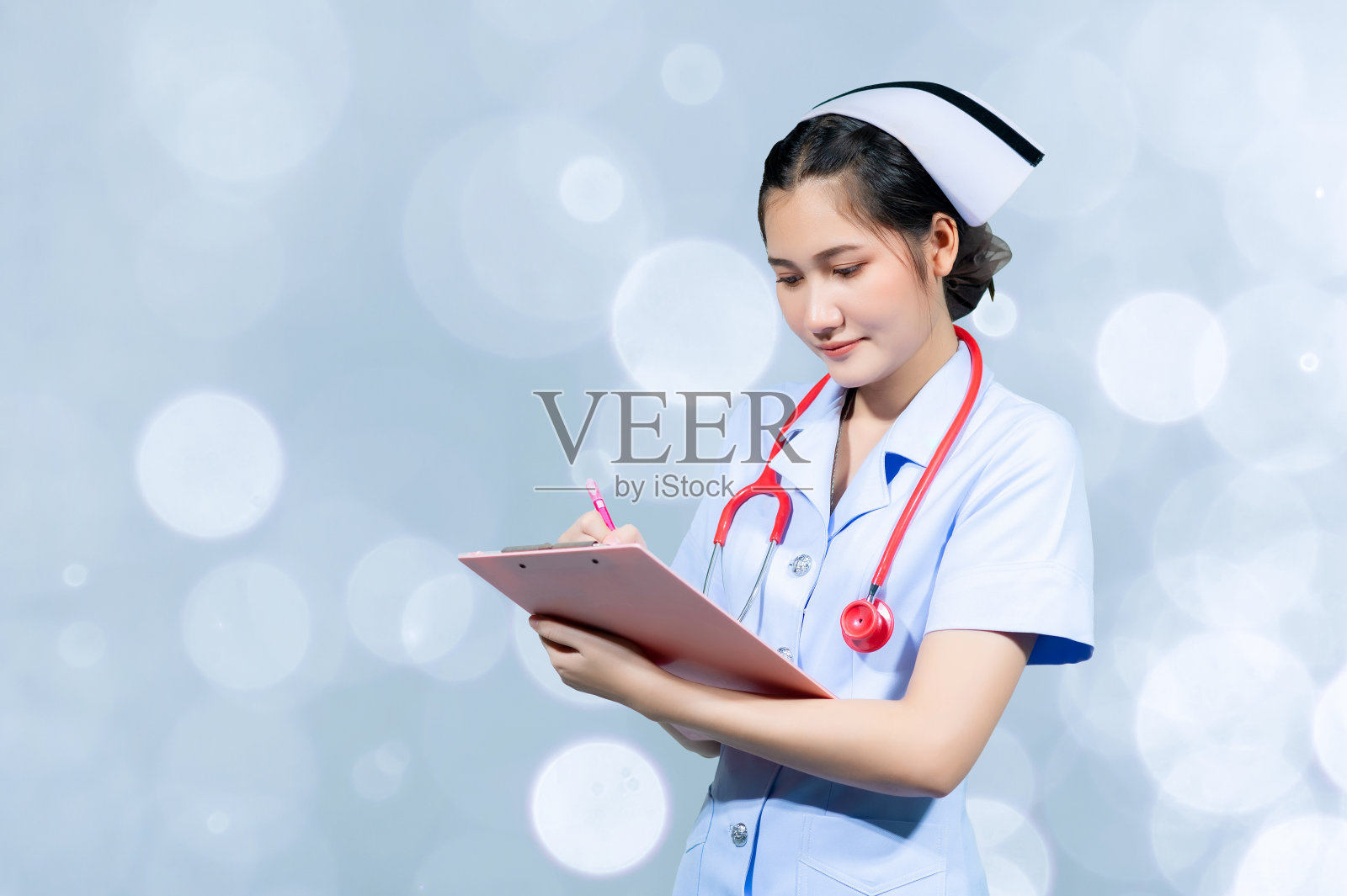 女医生在病人的病史报告上做记录照片摄影图片