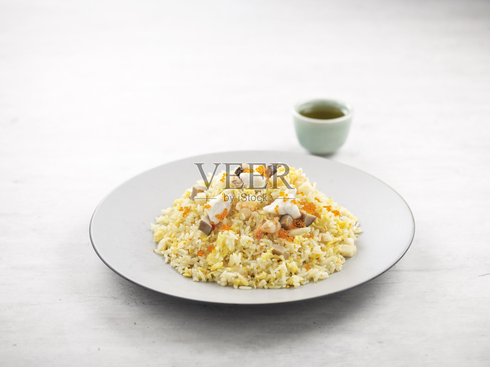 海鲜炒饭和Ebiko在一个菜的侧视图在灰色的背景照片摄影图片